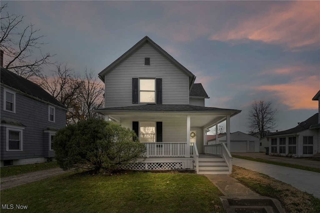 farmhouse inspired home featuring covered porch and a yard