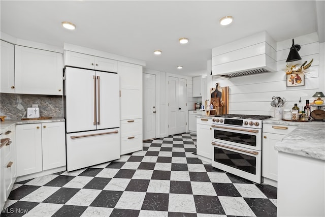 kitchen featuring tasteful backsplash, high quality appliances, custom range hood, and white cabinets