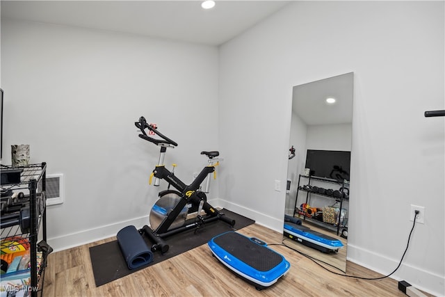 exercise room with hardwood / wood-style floors