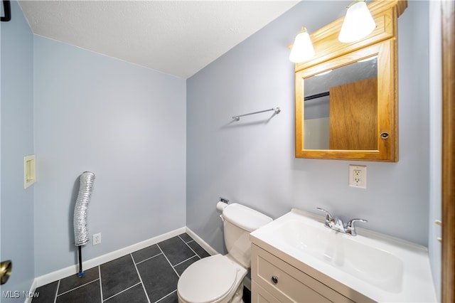 bathroom with tile patterned flooring, vanity, a textured ceiling, and toilet