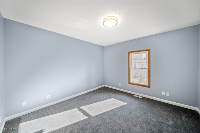 carpeted empty room with a textured ceiling