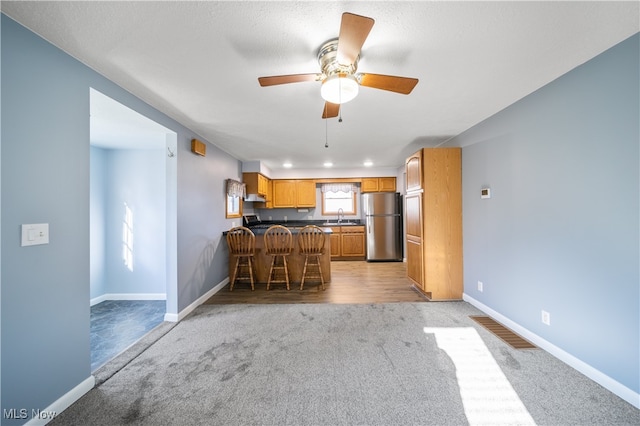 kitchen with light carpet, stainless steel fridge, ceiling fan, and sink