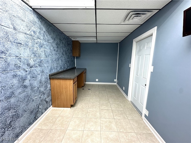 kitchen featuring a drop ceiling and light tile patterned floors