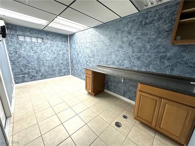 bathroom with a paneled ceiling and tile patterned floors