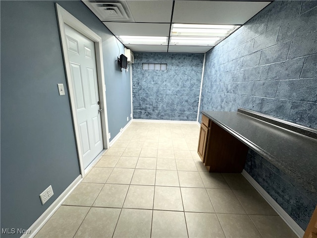 hallway with light tile patterned floors and tile walls