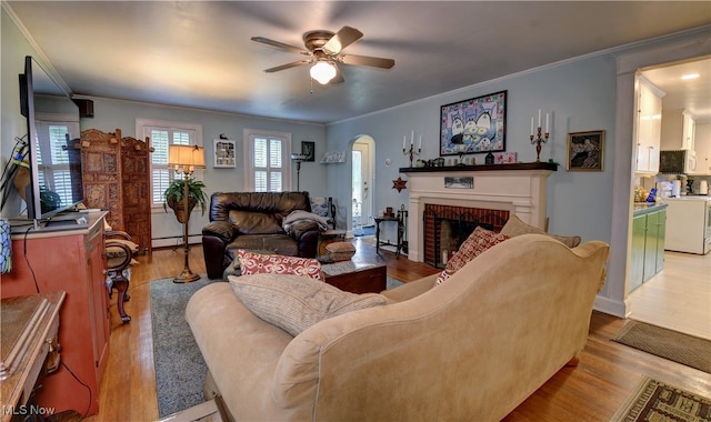 living room with crown molding, a baseboard radiator, and light wood-type flooring