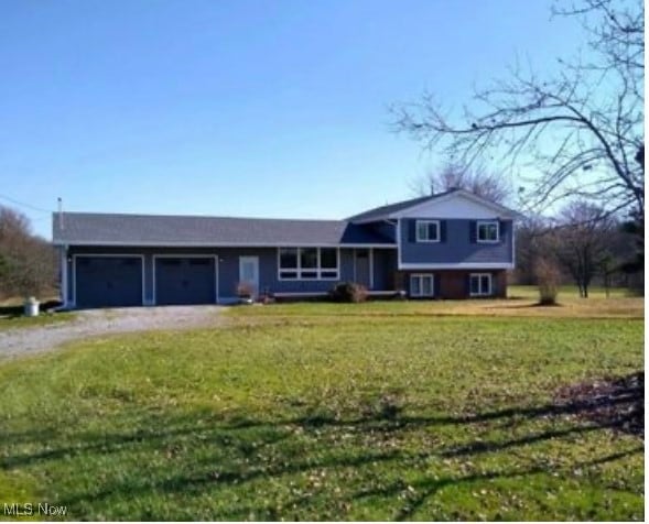 tri-level home with a garage and a front lawn