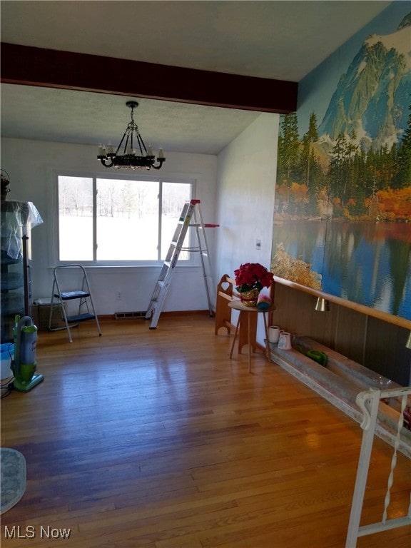 dining room featuring wood-type flooring, vaulted ceiling with beams, and an inviting chandelier