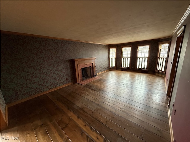 unfurnished living room featuring a fireplace, wood-type flooring, and ornamental molding