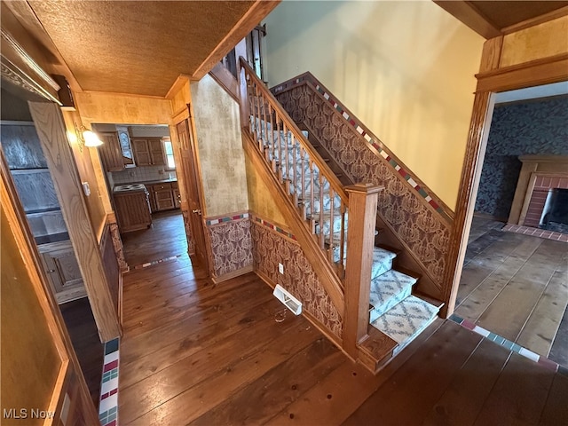 staircase with hardwood / wood-style flooring and a fireplace