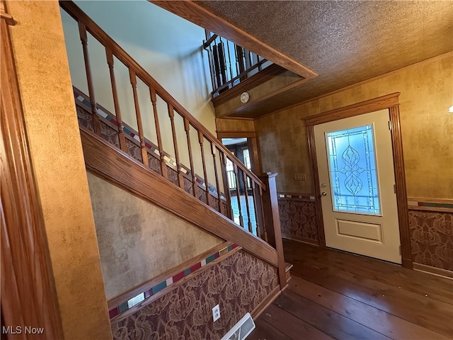 entryway featuring a textured ceiling and dark hardwood / wood-style floors