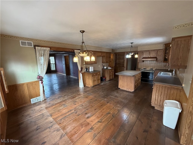 kitchen with pendant lighting, a center island, range with electric stovetop, tasteful backsplash, and dark hardwood / wood-style flooring