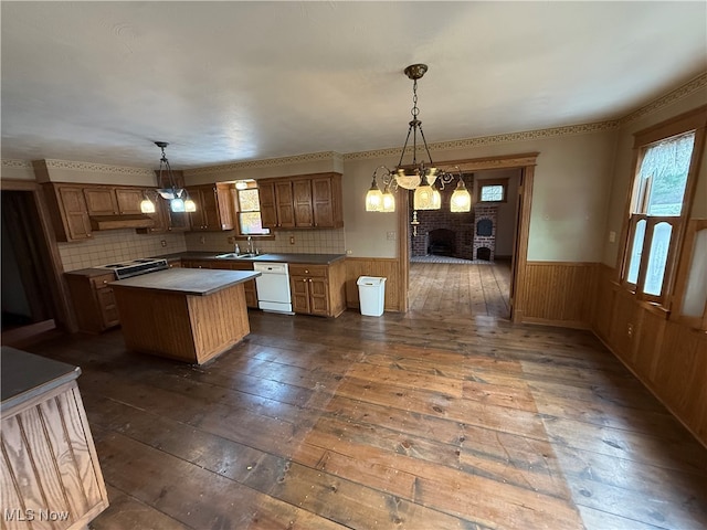 kitchen with tasteful backsplash, dark hardwood / wood-style flooring, white dishwasher, decorative light fixtures, and a kitchen island