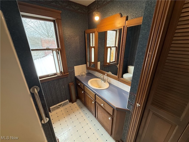 bathroom featuring plenty of natural light, vanity, and toilet