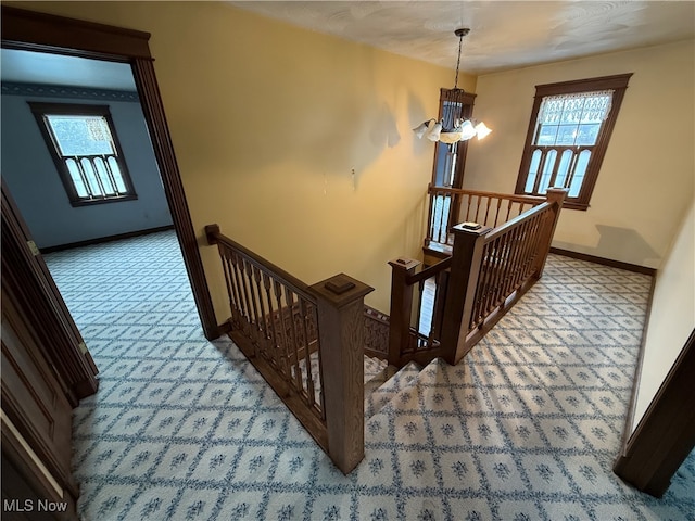 stairs featuring carpet and a notable chandelier