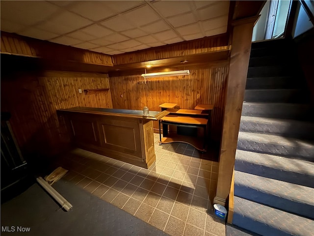 bar with wood walls and a drop ceiling