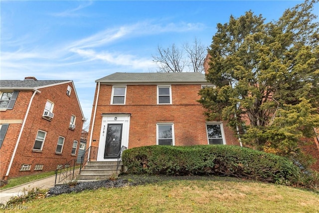 view of front of property featuring a front lawn and brick siding