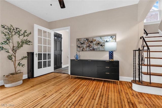 3781 Washington Blvd, University Heights, OH 44118 - unfurnished living room featuring hardwood / wood-style flooring, stairway, baseboards, and a ceiling fan