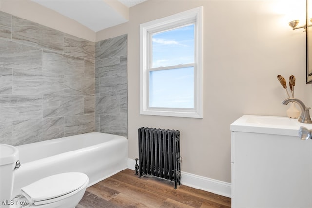 bathroom with radiator heating unit, vanity, hardwood / wood-style flooring, and toilet