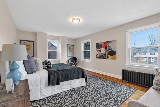 3781 Washington Blvd, University Heights, OH 44118 - bedroom with radiator, wood finished floors, and baseboards