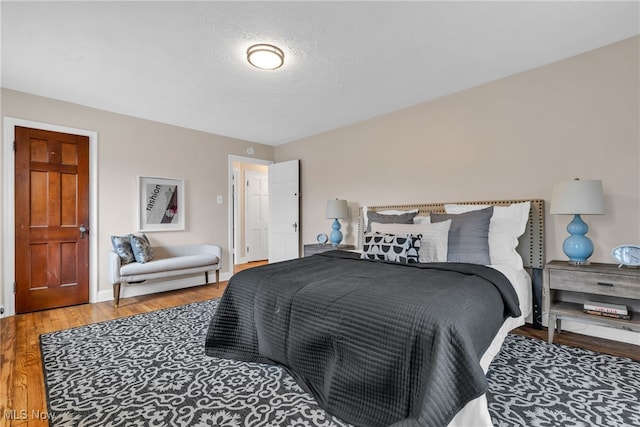 bedroom with wood-type flooring and a textured ceiling