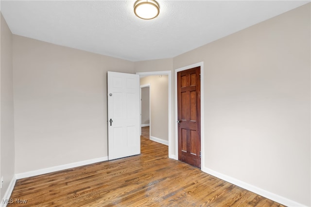 spare room featuring hardwood / wood-style flooring and a textured ceiling