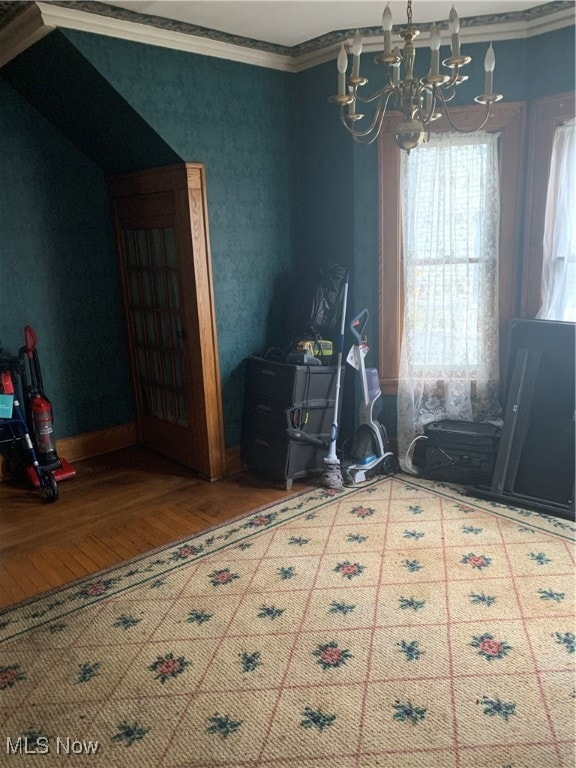 interior space with a chandelier, hardwood / wood-style flooring, and ornamental molding