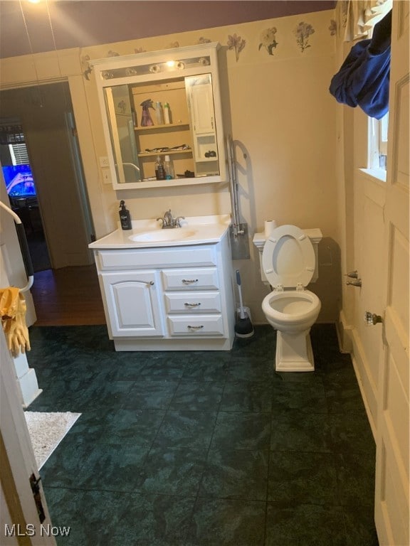 bathroom featuring tile patterned floors, vanity, and toilet