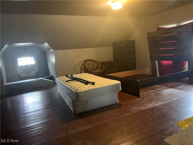 bedroom with dark wood-type flooring and lofted ceiling