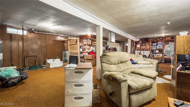 living room featuring wooden walls and dark carpet