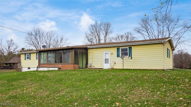 rear view of property with a yard and a sunroom