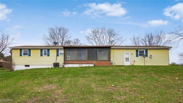 rear view of property featuring central AC, a sunroom, and a yard