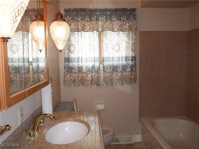 bathroom with toilet, sink, and a washtub