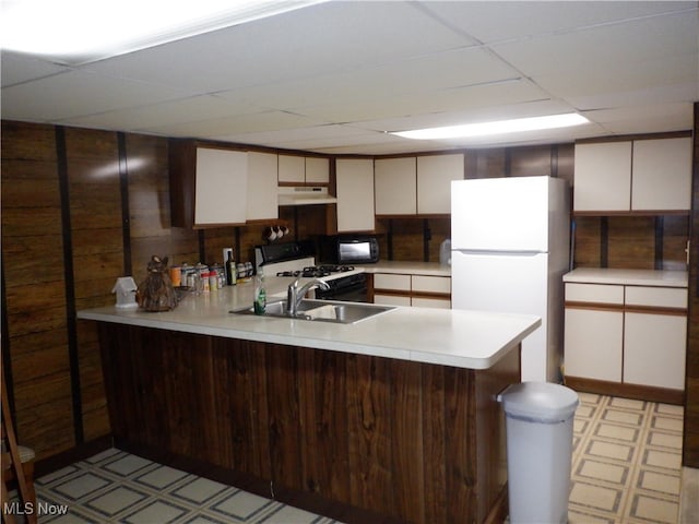 kitchen featuring kitchen peninsula, a paneled ceiling, white appliances, sink, and white cabinets