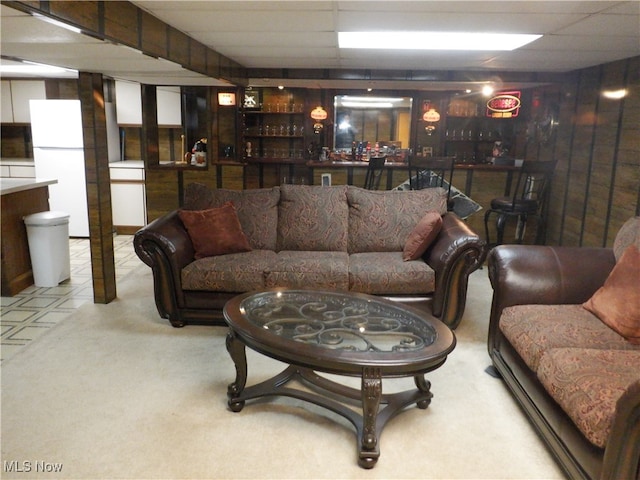 carpeted living room with a drop ceiling and indoor bar