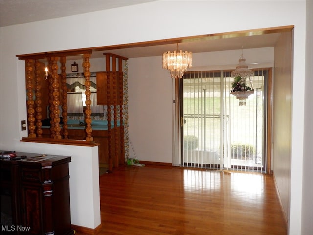 dining area with hardwood / wood-style flooring and an inviting chandelier