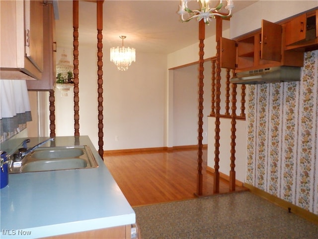 kitchen featuring hardwood / wood-style flooring, sink, hanging light fixtures, and an inviting chandelier