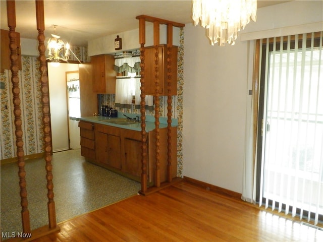 kitchen featuring sink, plenty of natural light, a notable chandelier, and light wood-type flooring