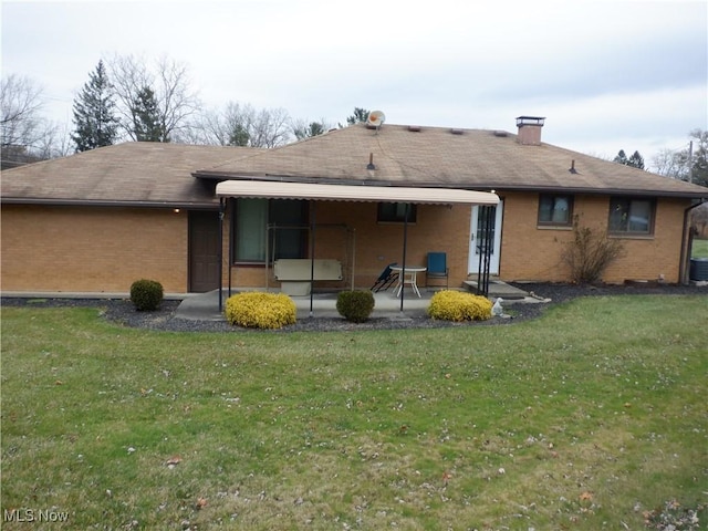 back of property featuring a yard, cooling unit, and a patio