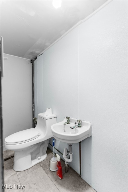 bathroom featuring tile patterned floors, toilet, and sink