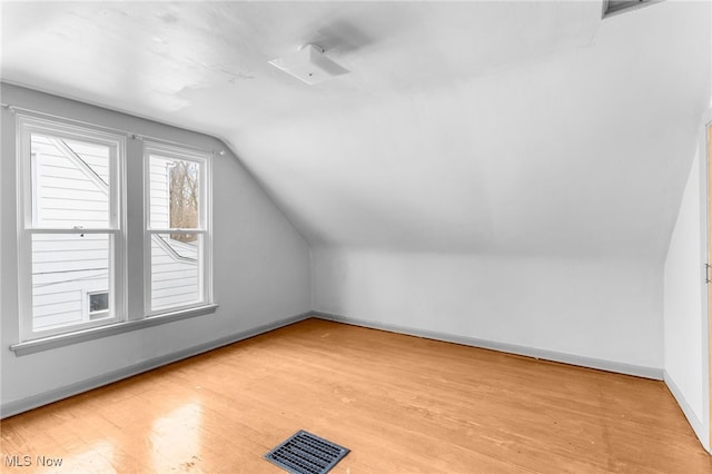 bonus room with light wood-type flooring and lofted ceiling