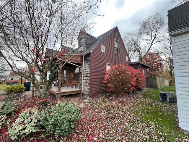 view of property exterior featuring central AC unit and a deck