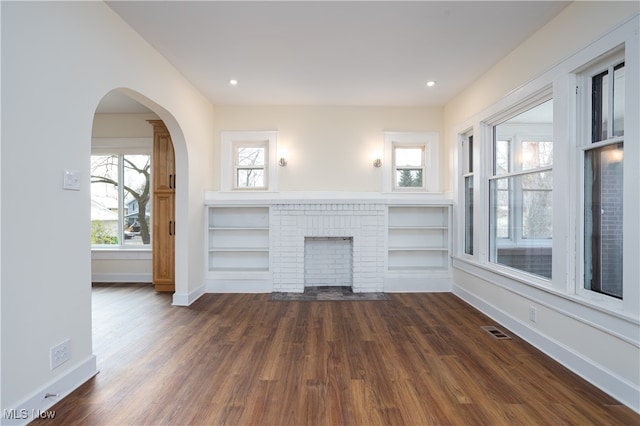 unfurnished living room with a fireplace and dark hardwood / wood-style flooring