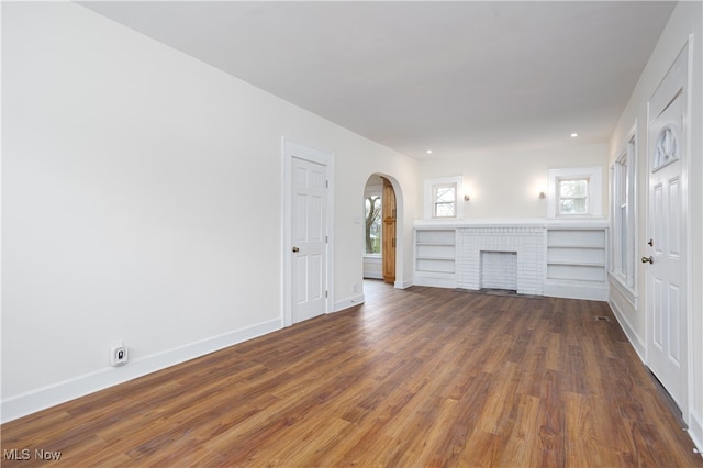 unfurnished living room with a fireplace and dark hardwood / wood-style floors