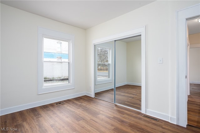 unfurnished bedroom with a closet and hardwood / wood-style flooring