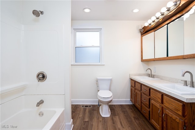 full bathroom with washtub / shower combination, toilet, wood-type flooring, and vanity