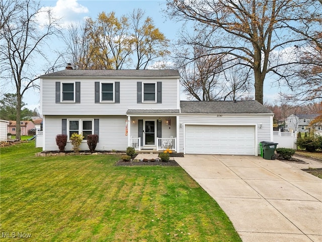 view of property featuring a garage and a front lawn