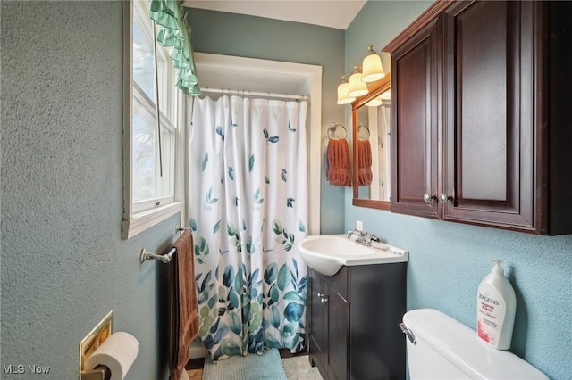 bathroom featuring a shower with curtain, vanity, and toilet