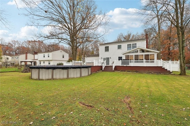 view of yard featuring a sunroom and a swimming pool side deck