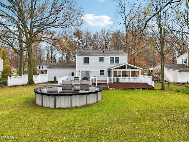 back of property featuring a swimming pool side deck and a lawn